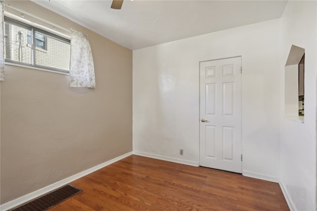 spare room featuring wood-type flooring and ceiling fan