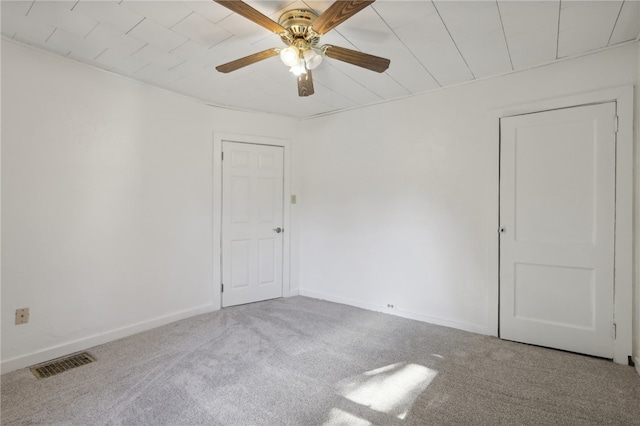 carpeted spare room featuring ceiling fan