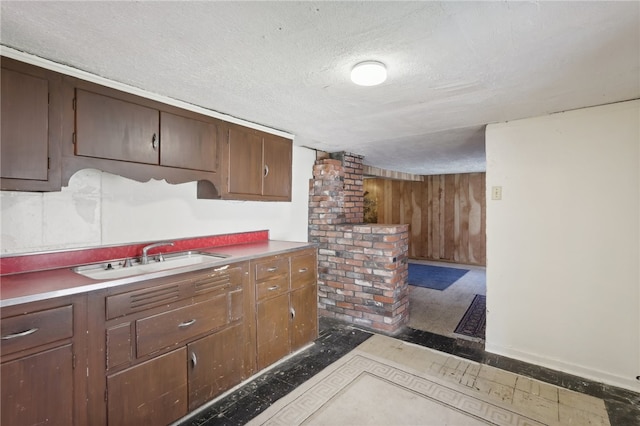 kitchen with a textured ceiling, sink, and ornate columns