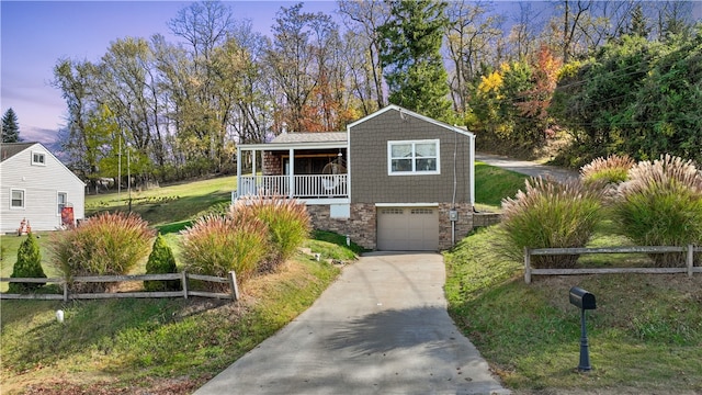 view of front of house featuring a lawn, a garage, and a porch