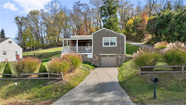 view of front of home featuring a front yard, a garage, and covered porch