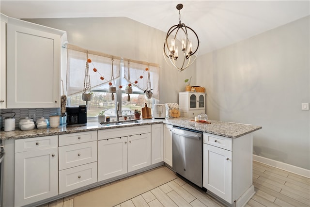 kitchen with dishwasher, vaulted ceiling, and white cabinets