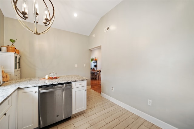 kitchen featuring light stone countertops, hanging light fixtures, vaulted ceiling, white cabinets, and stainless steel dishwasher