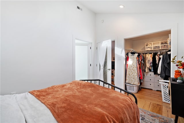 bedroom featuring hardwood / wood-style flooring, a closet, and high vaulted ceiling