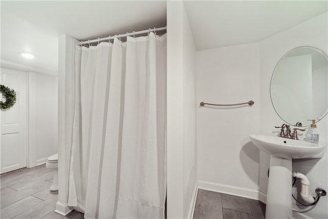 bathroom with wood-type flooring, toilet, and sink