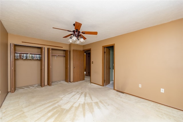 unfurnished bedroom featuring a textured ceiling, light colored carpet, and ceiling fan