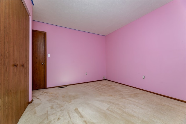 carpeted empty room with a textured ceiling