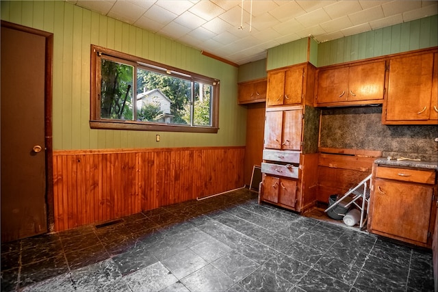 kitchen featuring wooden walls and backsplash