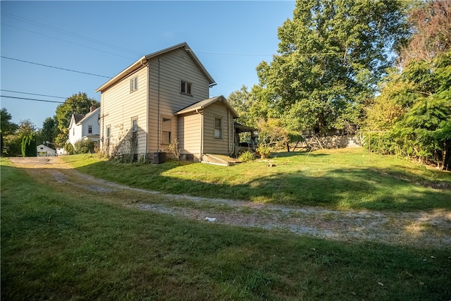 view of property exterior with a lawn and cooling unit