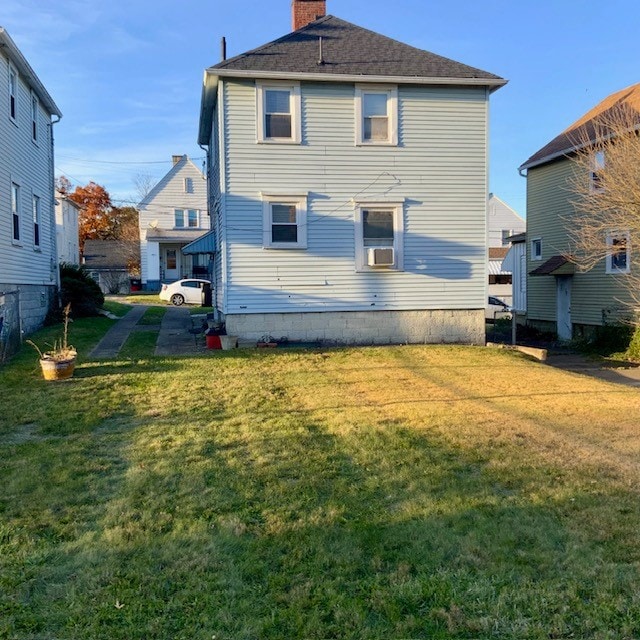 rear view of property with a yard