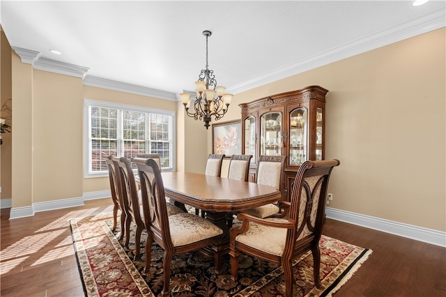 dining area with dark wood-type flooring, a notable chandelier, and ornamental molding