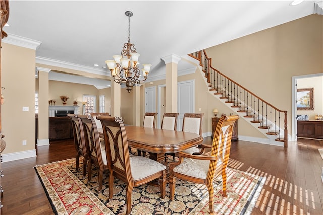 dining room featuring decorative columns, an inviting chandelier, dark hardwood / wood-style floors, and crown molding