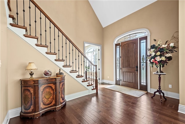 foyer entrance with high vaulted ceiling and hardwood / wood-style flooring