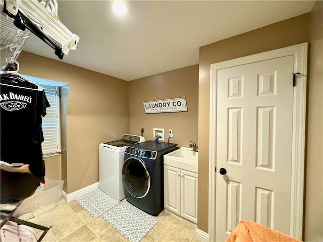 clothes washing area with cabinets, sink, and independent washer and dryer