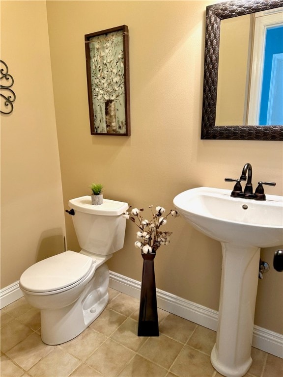 bathroom featuring toilet, sink, and tile patterned floors