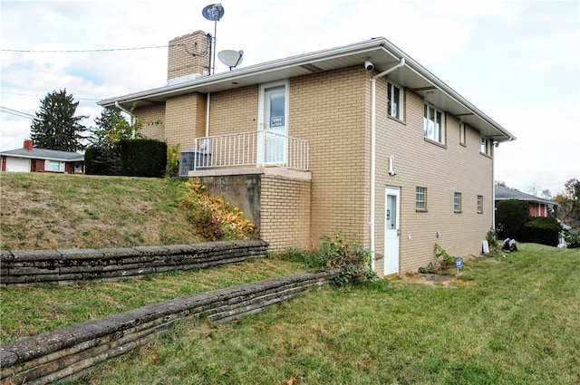 view of side of home with a yard