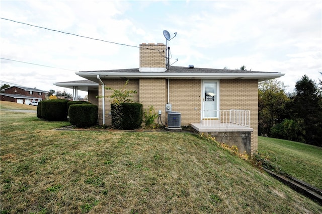 back of property featuring a lawn and cooling unit