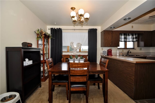 carpeted dining area featuring a healthy amount of sunlight, sink, and an inviting chandelier