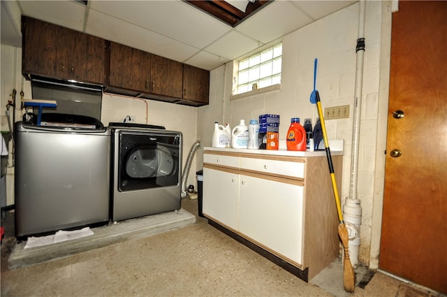 laundry area featuring separate washer and dryer and cabinets