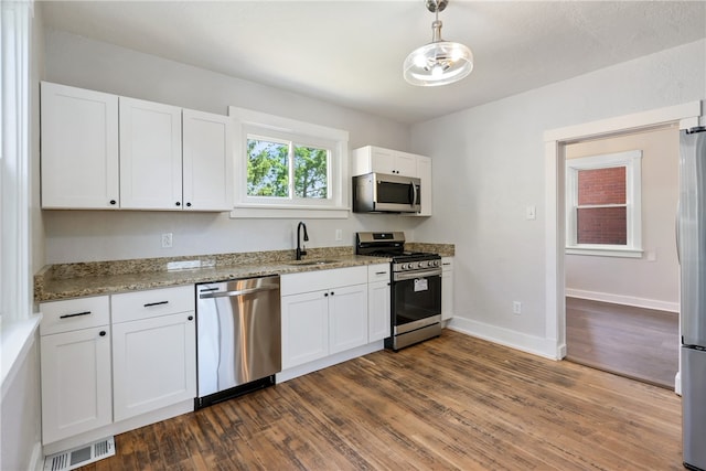 kitchen featuring appliances with stainless steel finishes, white cabinetry, and sink