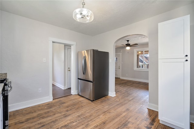 kitchen featuring stainless steel appliances, ceiling fan, pendant lighting, hardwood / wood-style floors, and white cabinetry