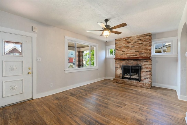 unfurnished living room with a fireplace, hardwood / wood-style floors, a textured ceiling, and ceiling fan