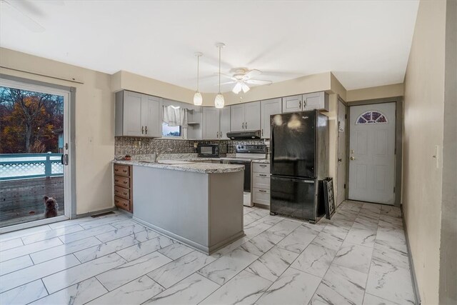 kitchen with range with electric stovetop, backsplash, black refrigerator, kitchen peninsula, and ceiling fan