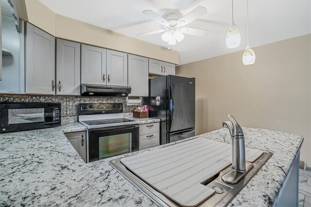 kitchen with gray cabinets, black appliances, and light stone countertops