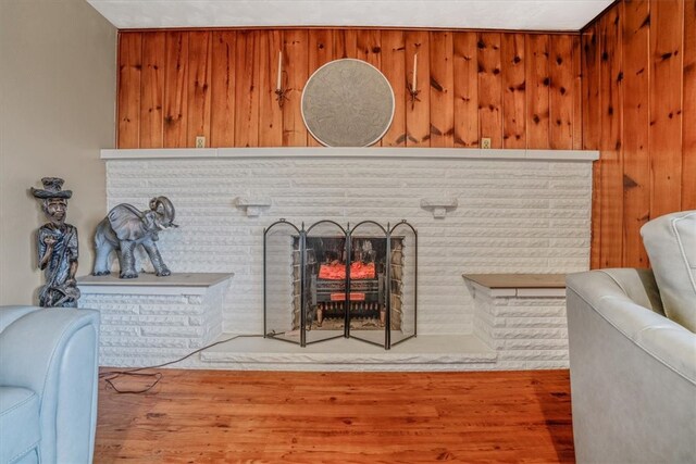 room details with a brick fireplace, hardwood / wood-style flooring, and wooden walls