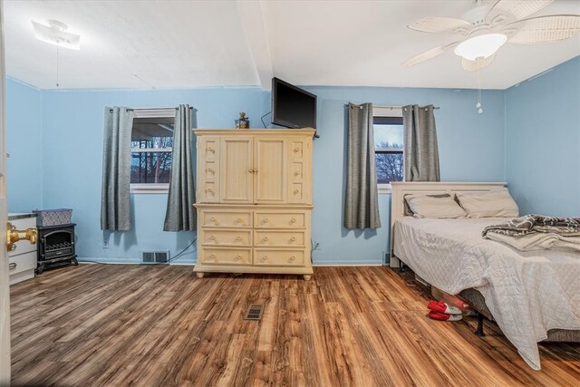 bedroom featuring hardwood / wood-style floors, beamed ceiling, and ceiling fan