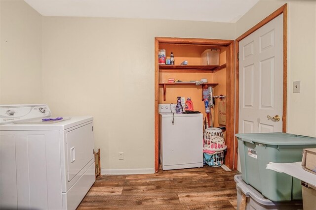 clothes washing area with dark hardwood / wood-style flooring and washer and clothes dryer