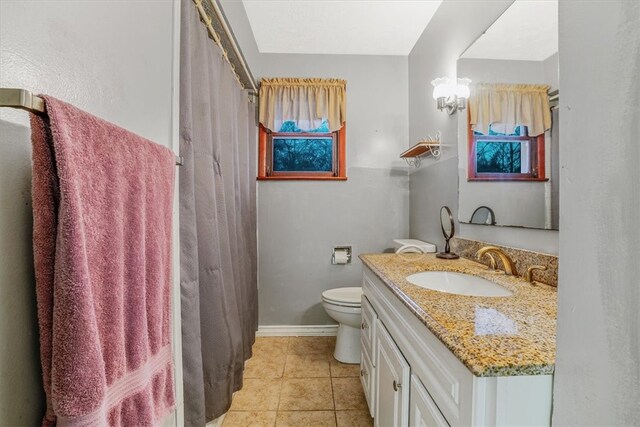 bathroom featuring toilet, walk in shower, vanity, and tile patterned floors