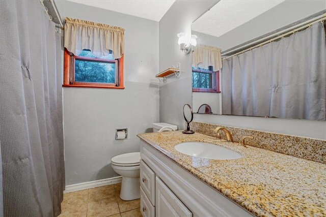 bathroom with tile patterned flooring, vanity, and toilet