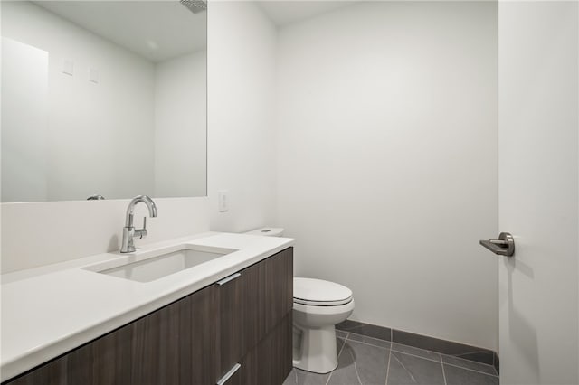 bathroom featuring toilet, vanity, and tile patterned flooring