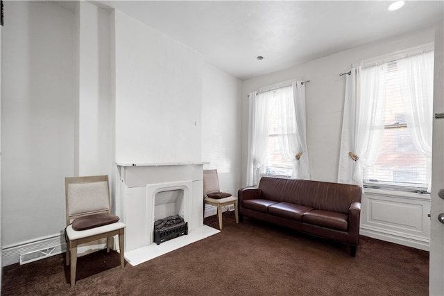 sitting room featuring a healthy amount of sunlight and dark carpet