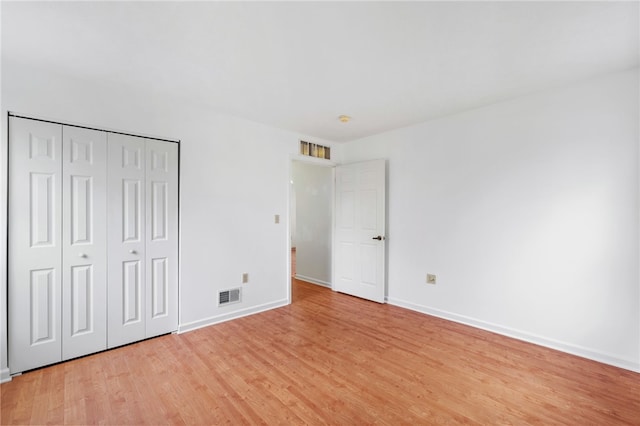 unfurnished bedroom with light hardwood / wood-style flooring and a closet