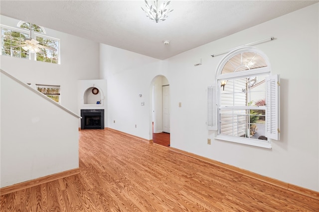 unfurnished living room with hardwood / wood-style floors, a textured ceiling, and ceiling fan