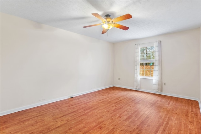 empty room featuring light wood-type flooring, a textured ceiling, and ceiling fan