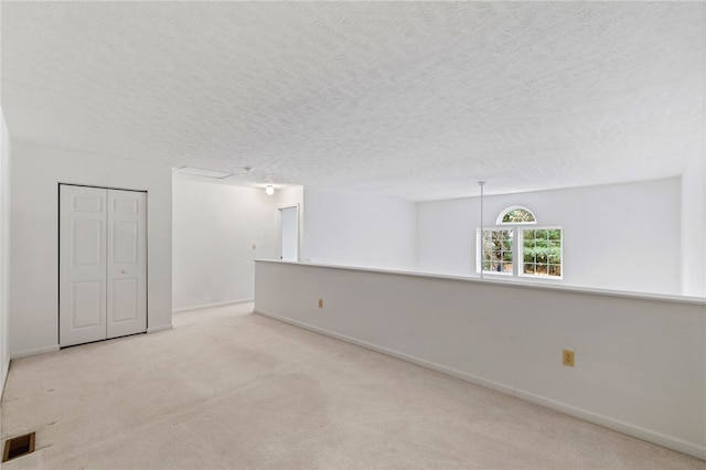 carpeted empty room with a textured ceiling