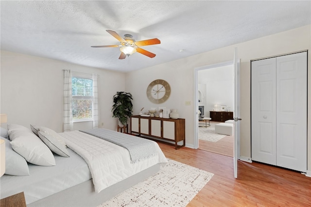 bedroom featuring hardwood / wood-style flooring, ceiling fan, and a textured ceiling