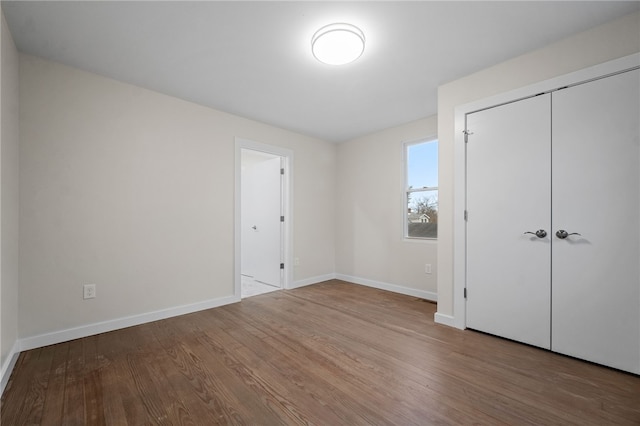 unfurnished bedroom featuring hardwood / wood-style floors and a closet