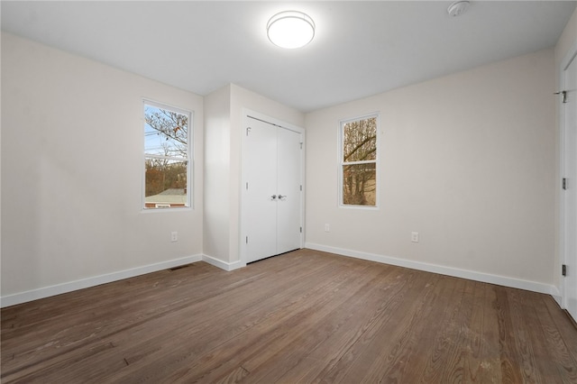 unfurnished bedroom with a closet and wood-type flooring