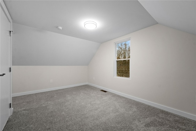 additional living space with lofted ceiling and carpet flooring