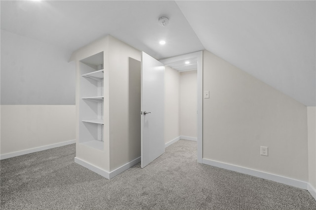 bonus room with built in shelves, carpet flooring, and lofted ceiling