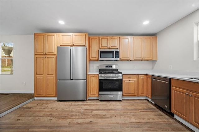 kitchen with light brown cabinets, light wood-type flooring, and appliances with stainless steel finishes