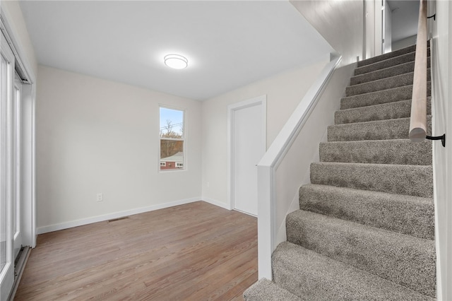 staircase with hardwood / wood-style floors