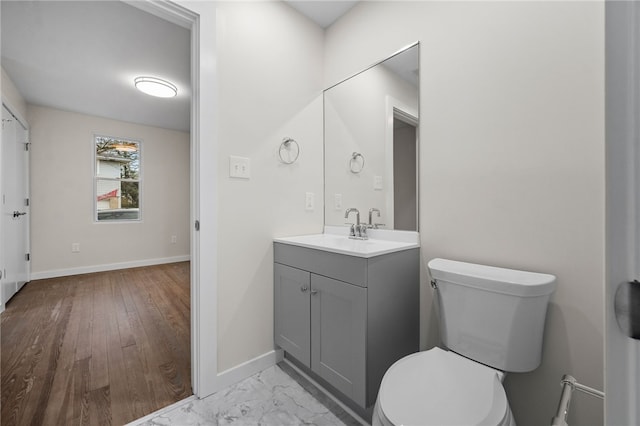 bathroom with toilet, vanity, and hardwood / wood-style floors