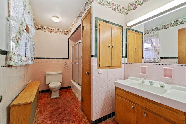 full bathroom with toilet, vanity, tile walls, and enclosed tub / shower combo