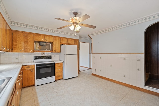 kitchen with white appliances, tile counters, and ceiling fan