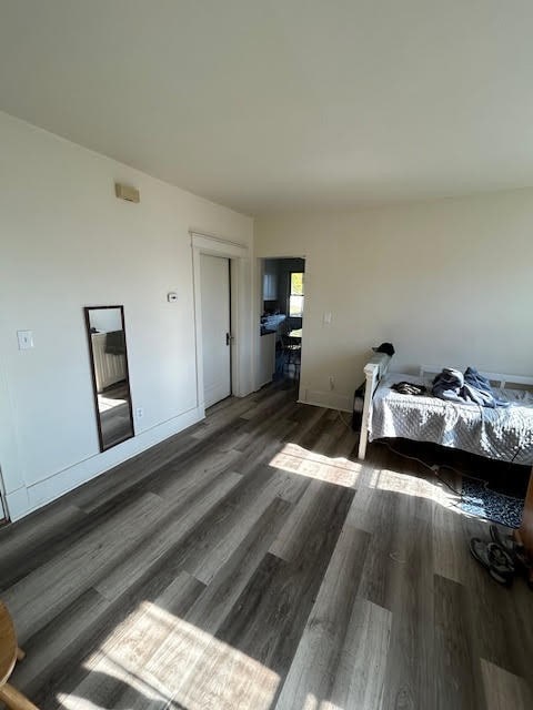 bedroom with dark hardwood / wood-style flooring